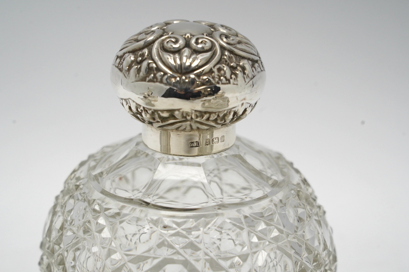 Four assorted early 20th century silver mounted glass scent bottles, tallest 16.1cm. Condition - fair